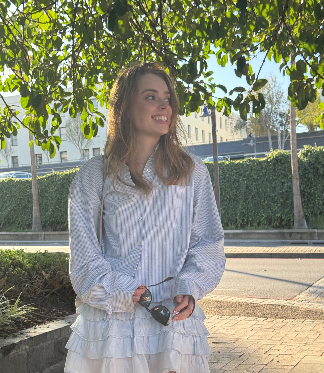 Hailey smiling under trees during remote tutoring session